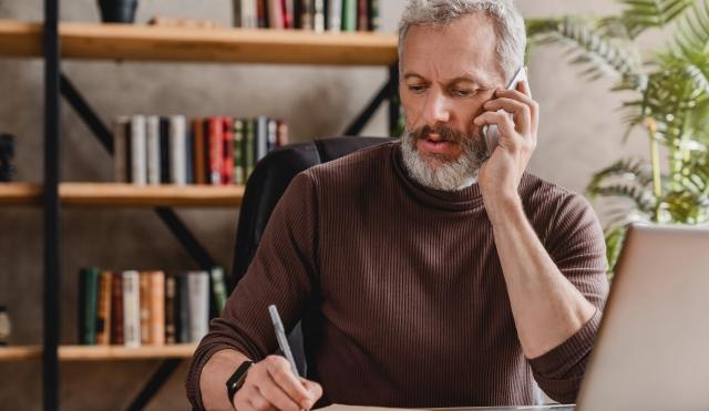 Man with phone taking notes